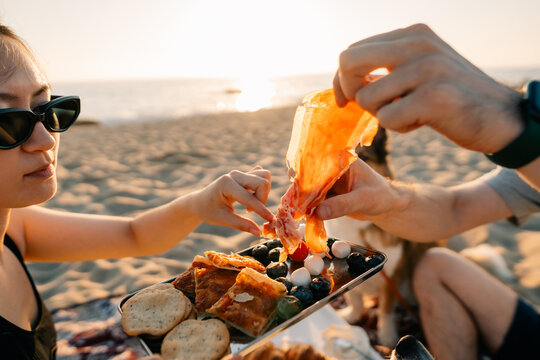 Picnic at Sunset on the Beach With Shared Food and Relaxation