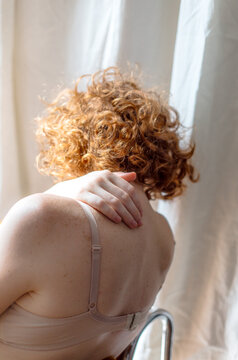 woman with bare back sitting in chair