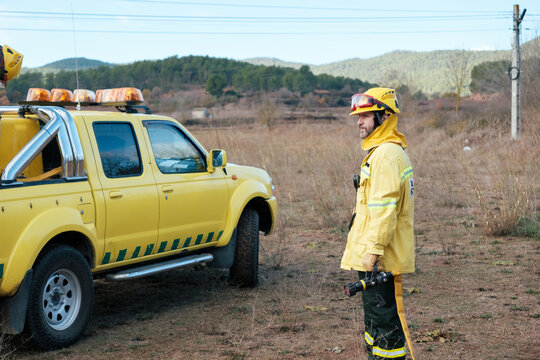 Fireman with a hose working on wildfire
