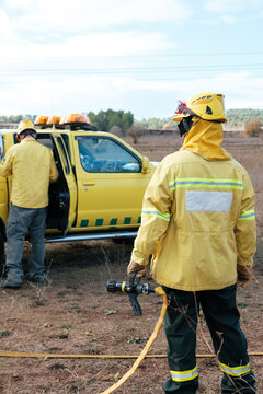 Fireman with a hose working on wildfire