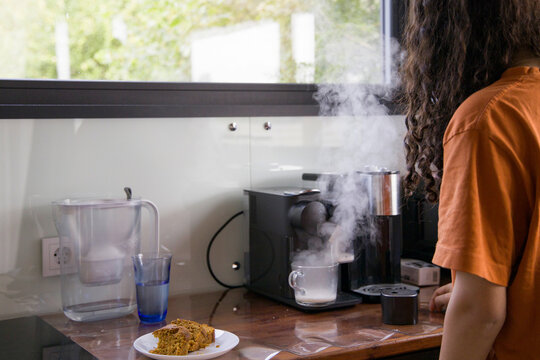Preparing a warm beverage in a cozy kitchen with delicious pastries 