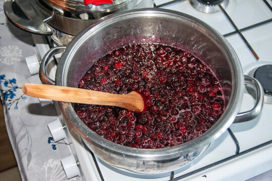 Preparing cherry jam in a pot on the stove