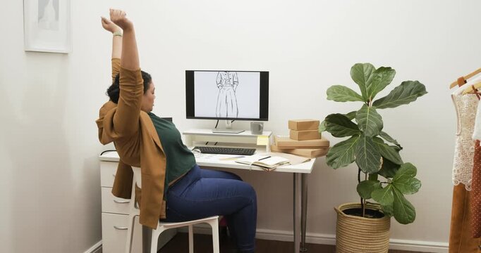 Designer is reviewing sketch at desk and writing notes, checking phone, sipping coffee, refocusing