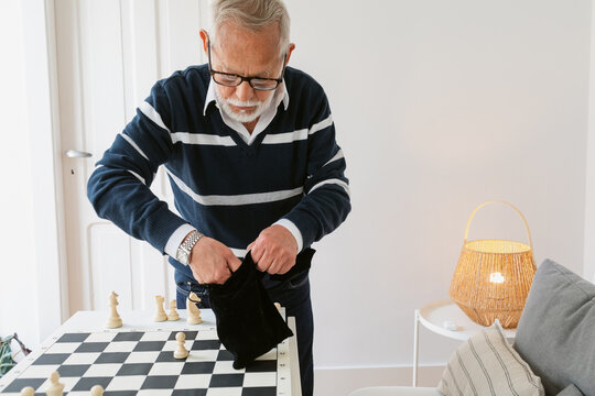 Senior Man Preparing Chess Pieces