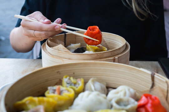An anonymous woman eating colorful dumplings