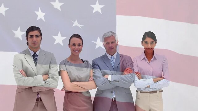 Team of four coming from edges centering folding arms posing flag rippling over group for portrait