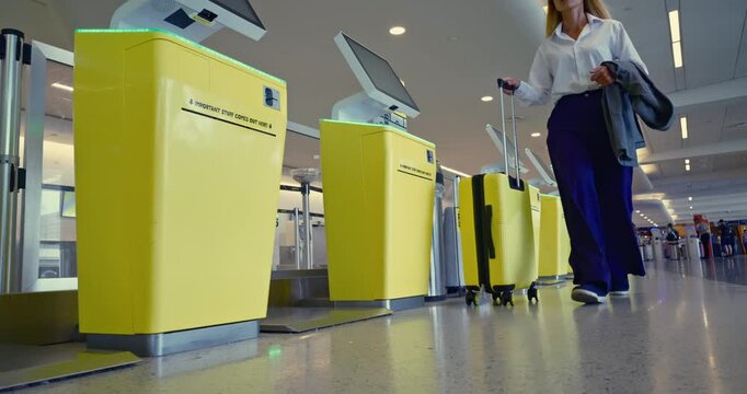 Traveler Passes Through Airport Security Checkpoint with Yellow Baggage