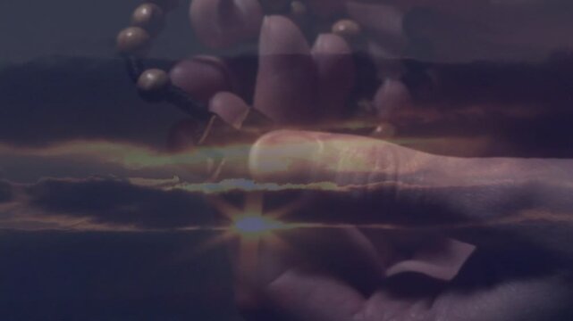 Fingers sliding bead strand over layered horizon, turning pendant, evoking calm reflection