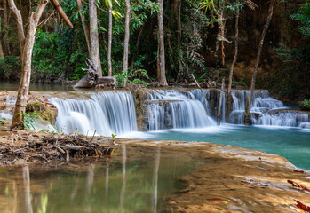Obraz premium Huay Mae Khamin Waterfalls cascading through lush forest in Sri Nakarin Dam National Park, Thailand. Green trees and rocks frame flowing streams. Tropical jungle landscape with fresh water.
