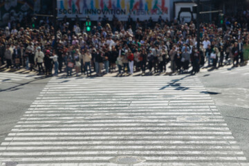 Obraz premium Shibuya Scramble Crossing, Tokyo, crowd of pedestrians and tourists walking on pedestrian crossing intersection during rush hour, Shibuya Station, Tokyo, Japan, passer-by walk in a sunny day