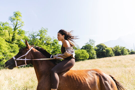 Woman Riding Horse Bareback in Meadow