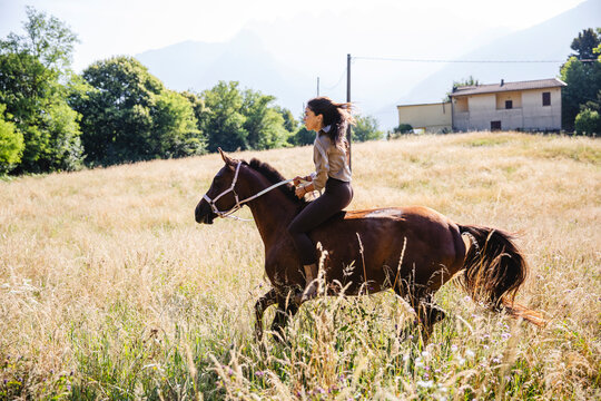 Woman Galloping Bareback on Horse in Field