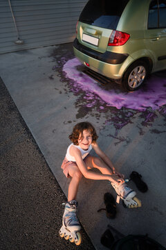 Little girl in roller skates at car wash