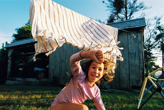 Happy child plays with laundry on the clothesline