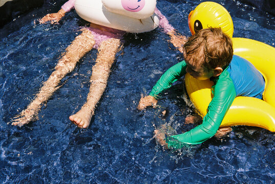 Children in kiddie pool with floaties