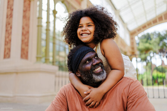 Grandfather and granddaughter sharing a happy moment outdoors