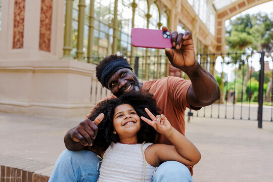 Grandfather and granddaughter taking a selfie and making gestures