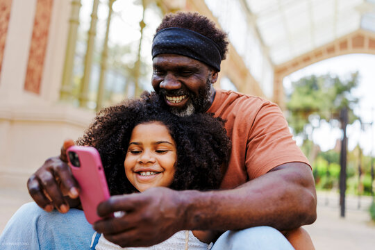 Grandfather and granddaughter sharing a special moment using phone