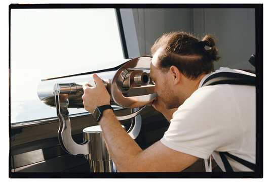 Person using a telescope to view distant landscape