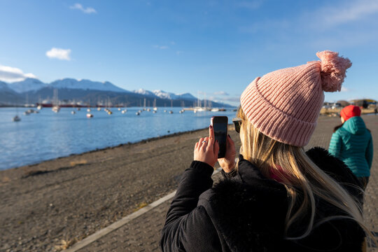 Woman Captures Scenic Waterfront View in Chilly Weather