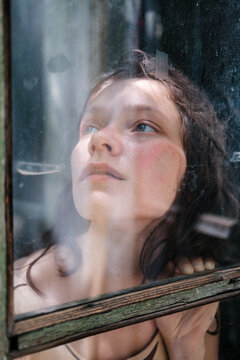 portrait of a woman behind a window glass