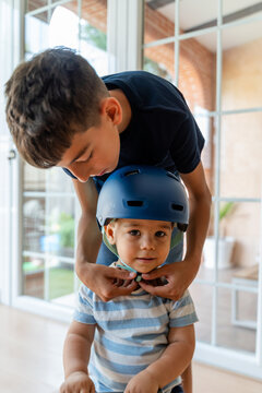 brother fastening his brother's helmet