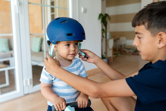 brother fastening his brother's helmet