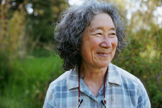 Elderly woman smiling outdoors in a candid portrait 
