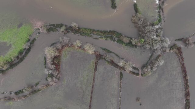River floodings event on the wide valley with farming fields and roads submerged. Still camera