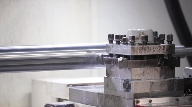 The robust tool post and the sharp cutting insert as it grazes the surface of spinning metal shaft.