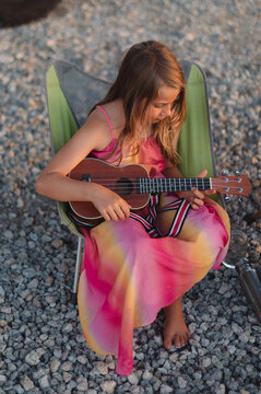 Girl Playing Ukulele in Camping Chair