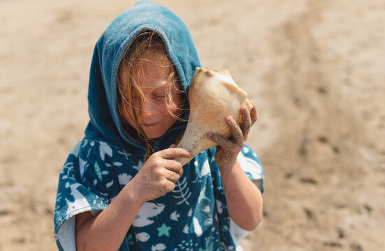 Child Listening to a Shell on the Beach