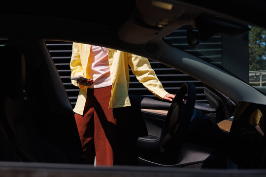 Person Holding Phone Beside Open Car Door
