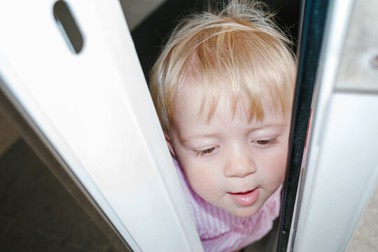 UGC Curious toddler peeking through sliding door at home