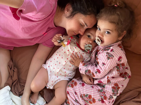 UGC selfie of playful moment with her two young children in bed