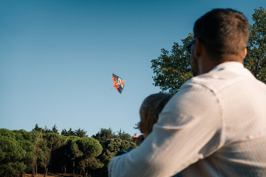 Family Enjoys a Sunny Day Flying a Colorful Kite in the Park