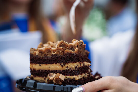 Slice of chocolate peanut butter layer cake with cookie dough topping