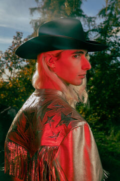 Portrait of a young man in a gold cowboy outfit and hat with red flash