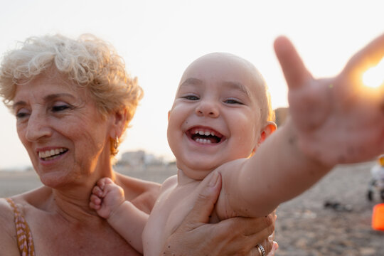 Grandmother holding laughing baby 