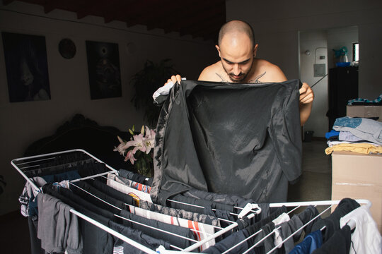 Man folding laundry at home in the late afternoon