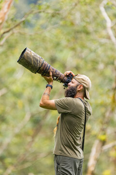 Wildlife photographer with telephoto lens in the jungle