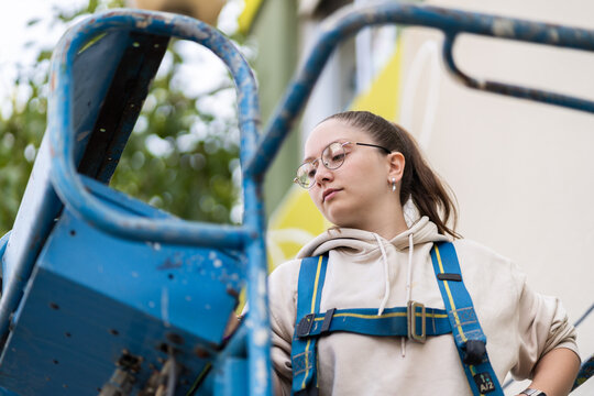 Female painter working on a lift is looking down