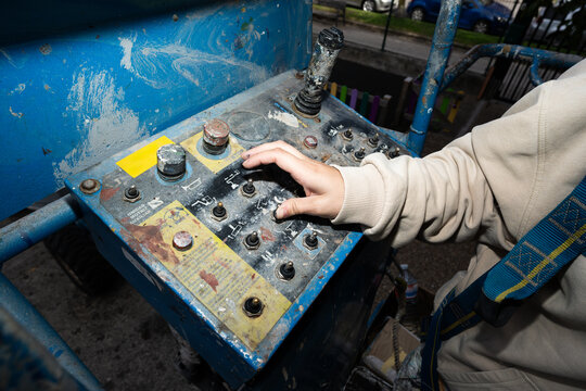 Painter operating machinery on aerial work platform
