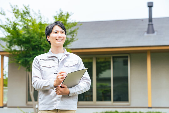 笑顔で住宅の前に立つ男性作業員