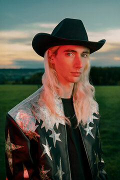 Portrait of a young man in a gold cowboy outfit and hat with red flash