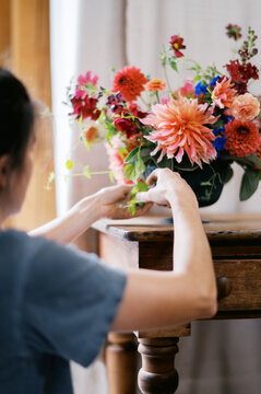 farmer designing a wedding bouquet with dahlia, cucamelon, flowers