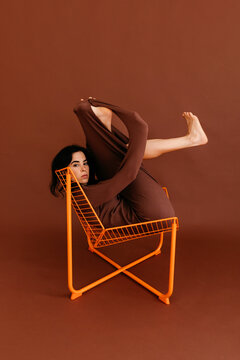 Flexible dancer performing on orange chair