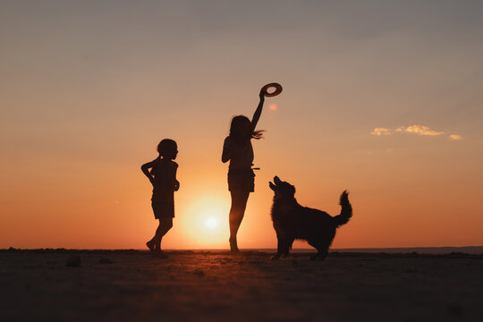 Silhouetted children playing at sunset