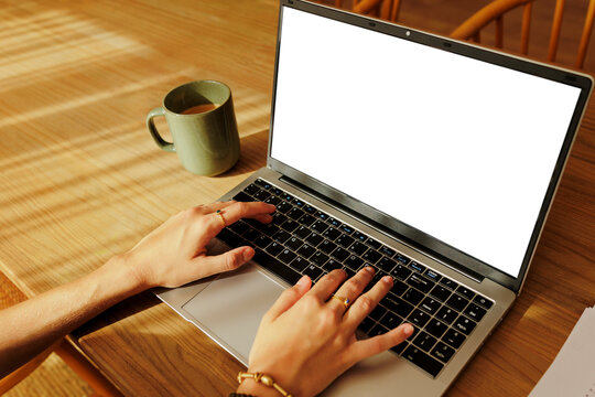 Woman working remotely from home with laptop and coffee