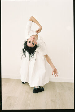 Dancer bending backwards in white dress